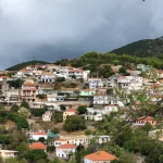 A scenic view of Agia Pargas village, nestled on a hillside, adorned with houses and trees.